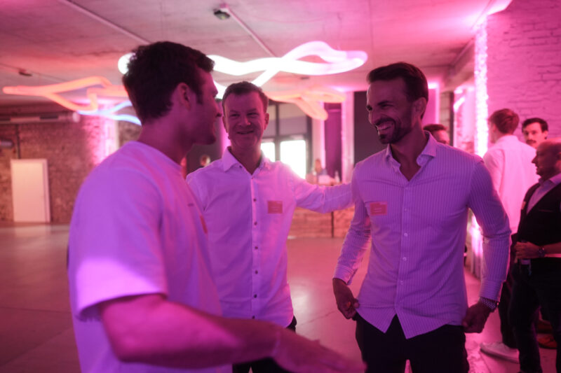 Die Abbildung zeigt drei lachende Männer im Gespräch vertieft.